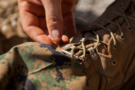 A service member laces up their boots.