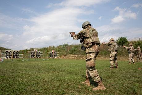 Soldiers shoot at a range while wearing body armor.