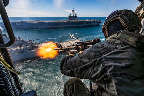 A Navy SEAL fires from a helicopter during training.
