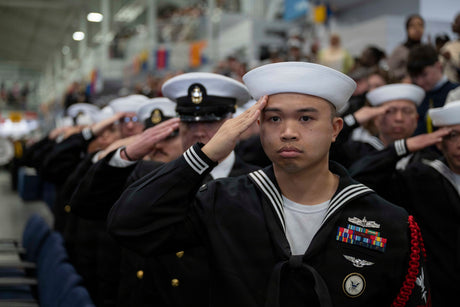 A sailor salutes during a formation.