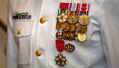 A Sailor wears full size military medals for an award ceremony.