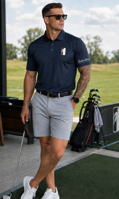 Broken 3 Wood - man in a navy embroidered polo and shorts on a golf driving range.