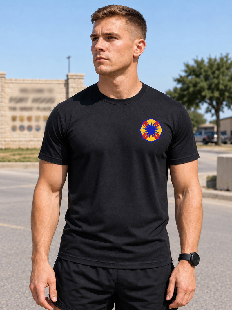 Soldier in a black unit t-shirt with an embroidered unit crest on the left chest, outside Fort Hood.